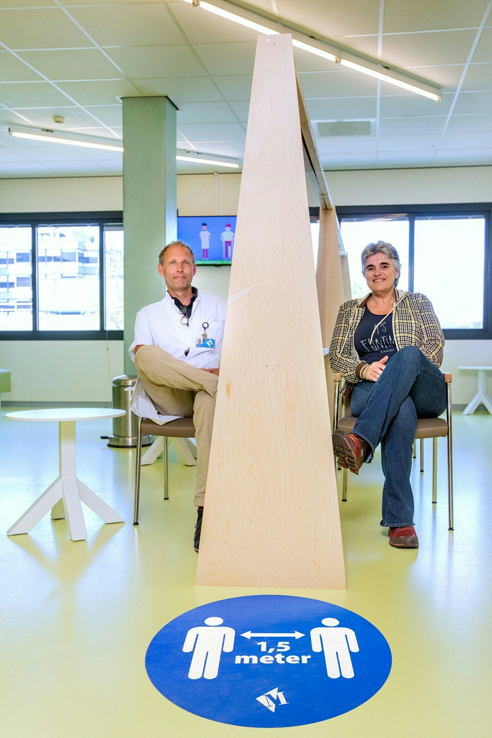 Gynecologist Marinus van der Ploeg and scheduler Marie-Jos Speelman sit down in the waiting room
