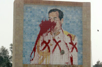 A defaced image of the former Iraqi dictator, Saddam Hussein. (Wikimedia Commons; U.S.M.C., Lance Cpl. Matthew R. Jones)