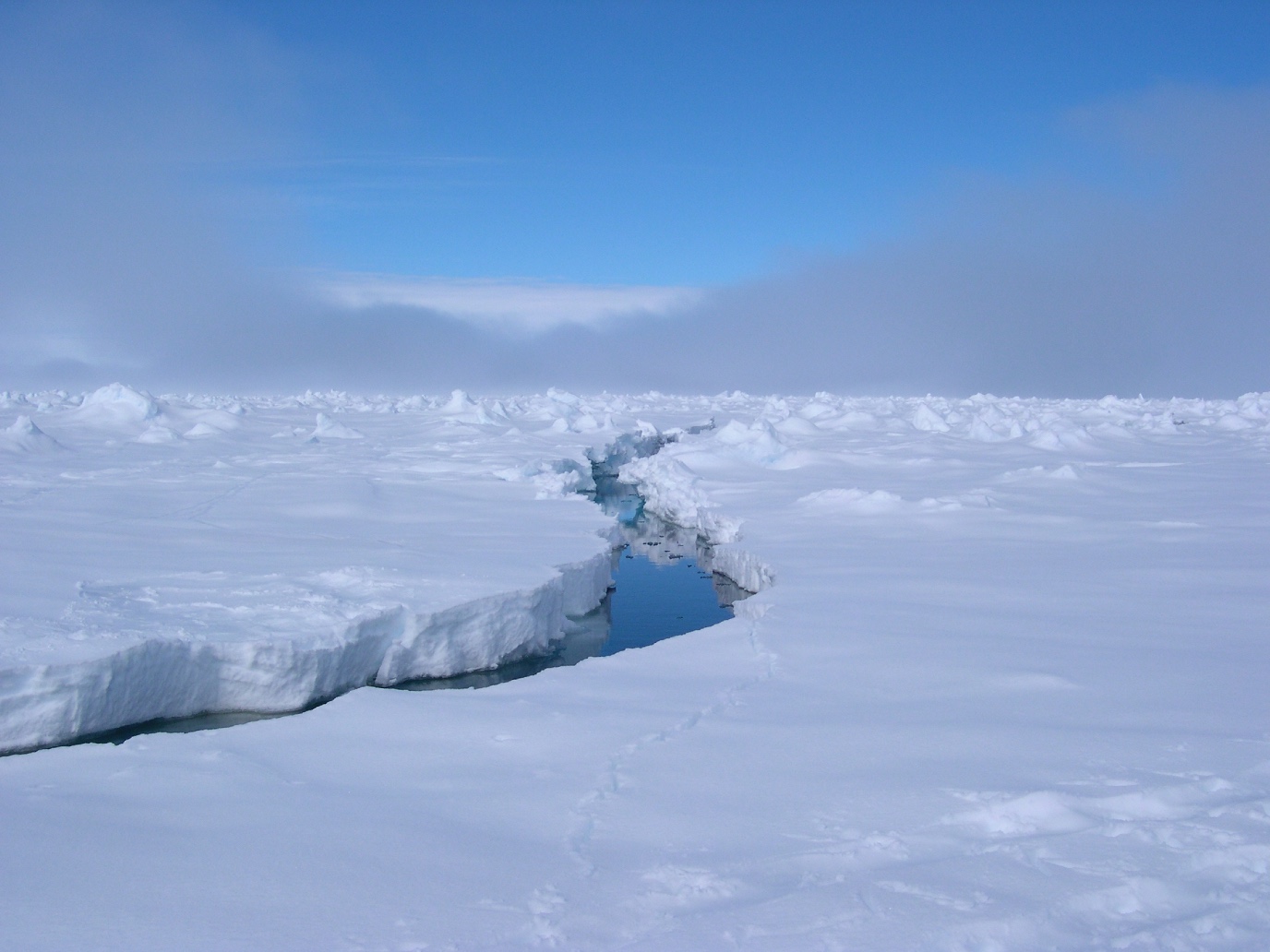 Een scheur in het ijs en wolken boven Antarctica